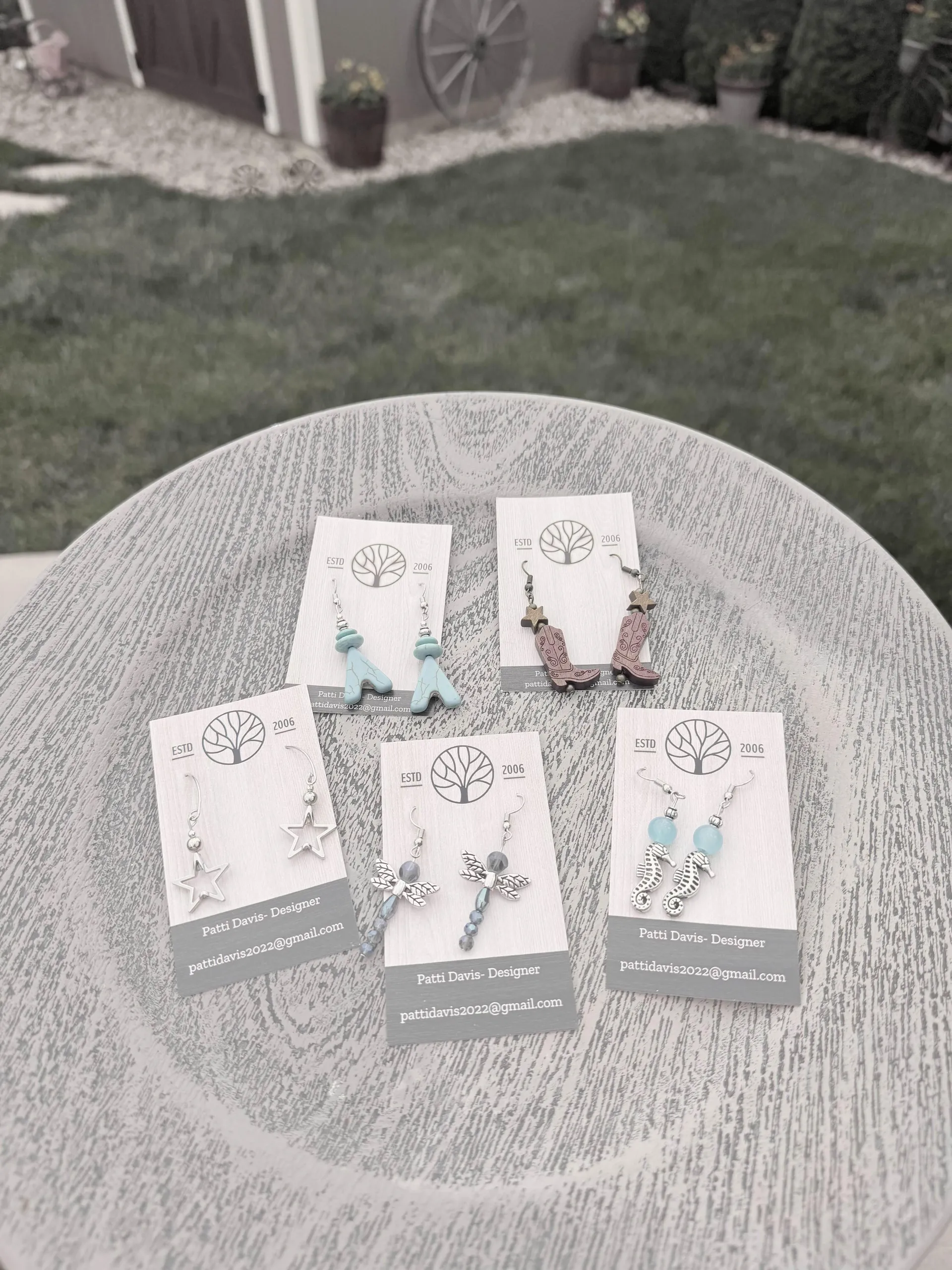 Patti Davis designer earrings — cowboy boots, stars, seahorses, and dragonflies on branded cards